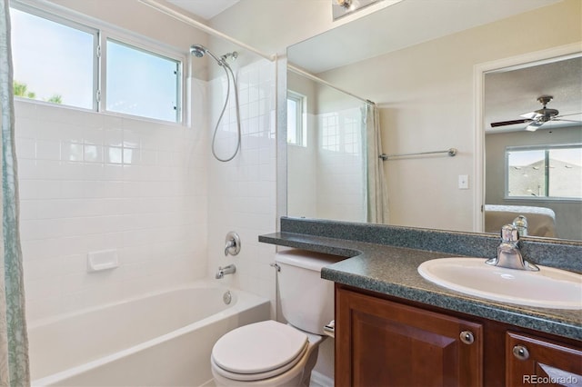 bathroom with shower / bath combination with curtain, a healthy amount of sunlight, vanity, and toilet