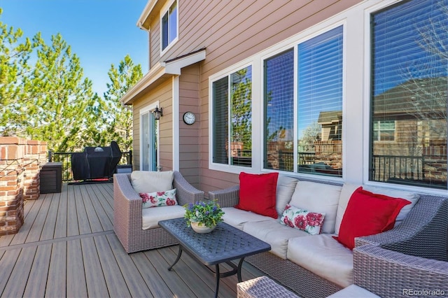 wooden terrace featuring an outdoor living space and area for grilling