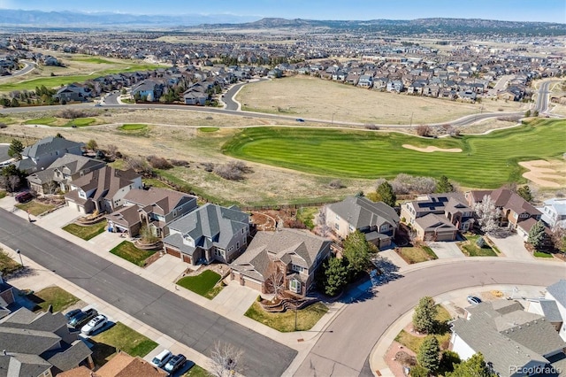 drone / aerial view with golf course view, a mountain view, and a residential view