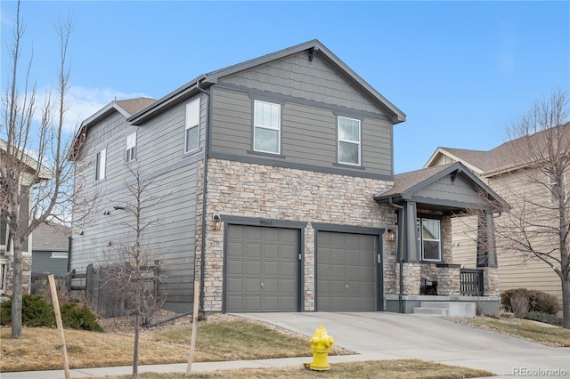 craftsman-style house featuring stone siding, an attached garage, and driveway