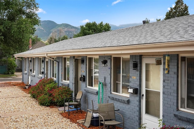 2922 W Bijou, Colorado Springs, CO 80904 - view of front of property featuring brick siding, a shingled roof, a mountain view, and a porch