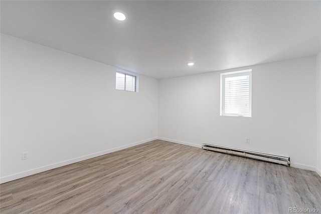 1486 S Kingston St, Aurora, CO 80012 - below grade area with a baseboard heating unit, wood finished floors, baseboards, and recessed lighting