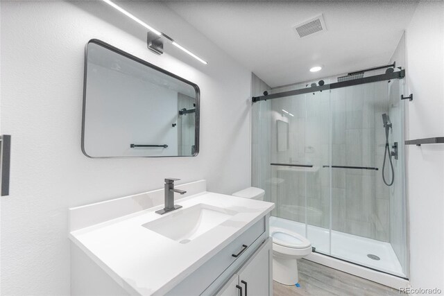 1486 S Kingston St, Aurora, CO 80012 - bathroom with toilet, a stall shower, vanity, and wood finished floors