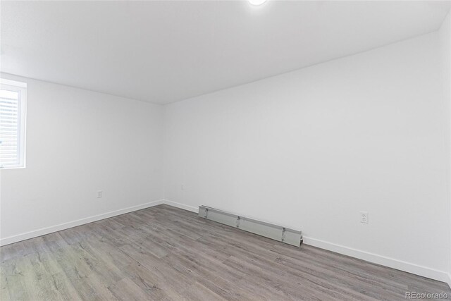 1486 S Kingston St, Aurora, CO 80012 - unfurnished room featuring a baseboard heating unit, wood finished floors, and baseboards