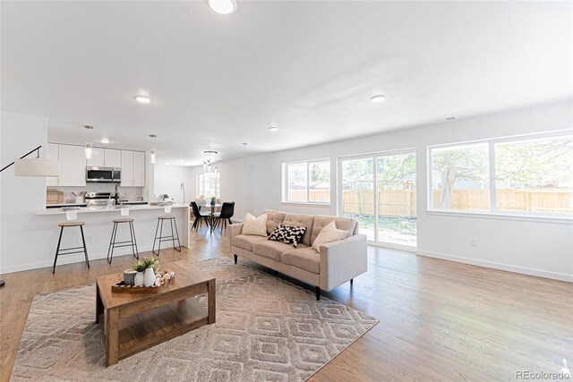1486 S Kingston St, Aurora, CO 80012 - living room with recessed lighting, baseboards, and light wood-style floors