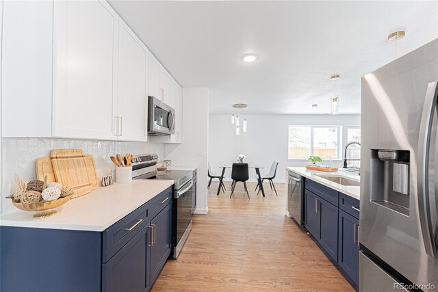 1486 S Kingston St, Aurora, CO 80012 - kitchen with stainless steel appliances, a sink, blue cabinetry, light countertops, and recessed lighting