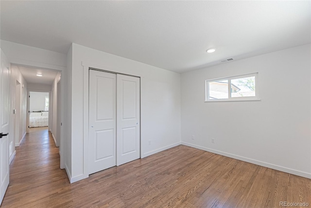 1486 S Kingston St, Aurora, CO 80012 - unfurnished bedroom with light wood-style floors, baseboards, a closet, and recessed lighting
