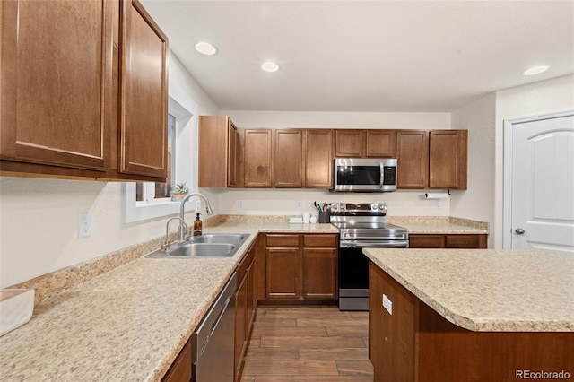 kitchen with dark wood-style flooring, a sink, light countertops, appliances with stainless steel finishes, and brown cabinets