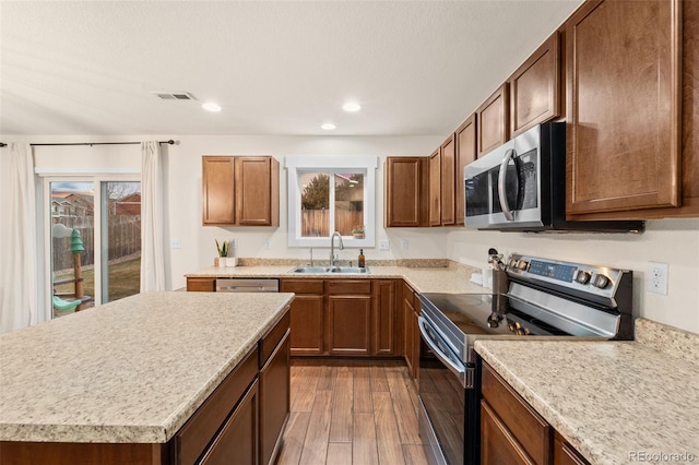 kitchen with visible vents, a sink, dark wood-style floors, appliances with stainless steel finishes, and light countertops