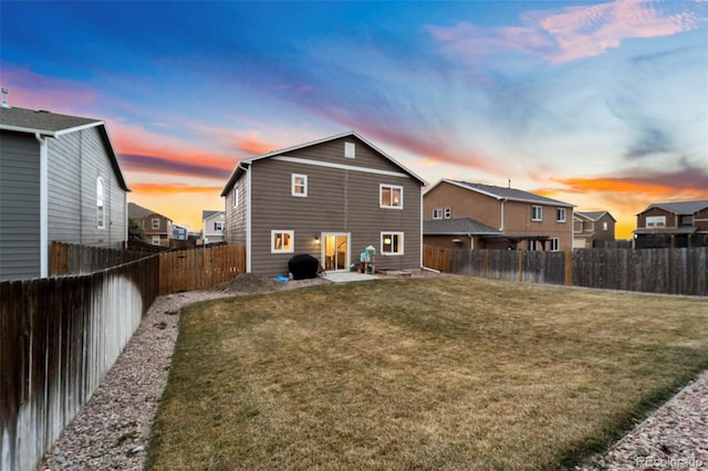 rear view of property with a lawn, a fenced backyard, and entry steps