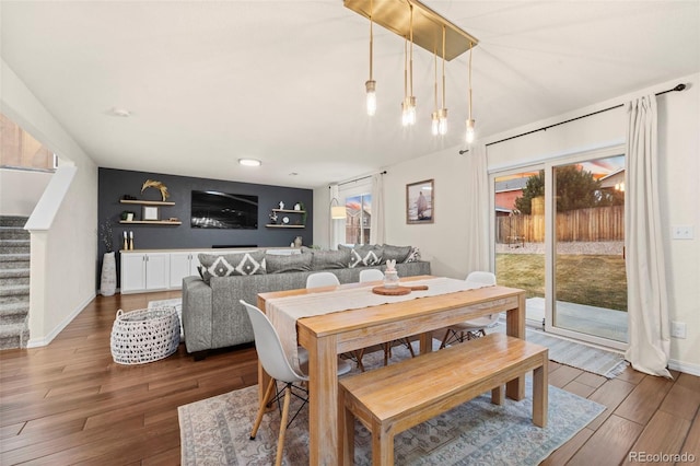 dining space featuring stairway, baseboards, and wood finished floors