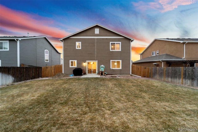 rear view of house with a patio area, a lawn, and a fenced backyard