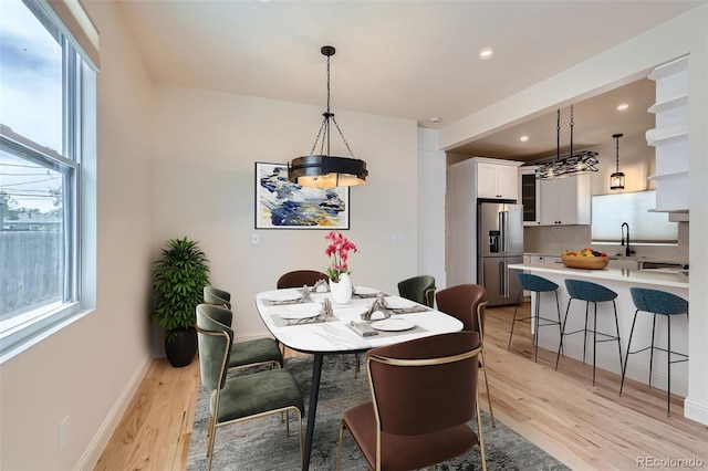 dining area with light wood finished floors, plenty of natural light, recessed lighting, and baseboards