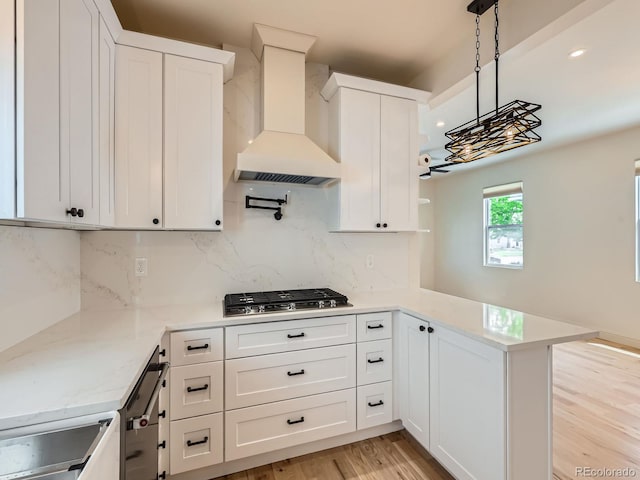 kitchen featuring custom exhaust hood, stainless steel gas stovetop, tasteful backsplash, white cabinets, and recessed lighting