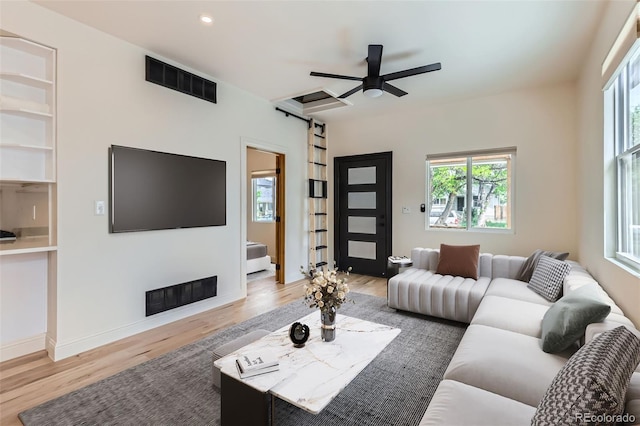 living room featuring a barn door, wood finished floors, healthy amount of natural light, a ceiling fan, and recessed lighting