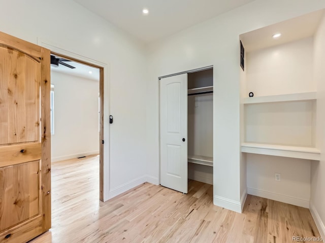 unfurnished bedroom featuring light wood finished floors, baseboards, a closet, and recessed lighting