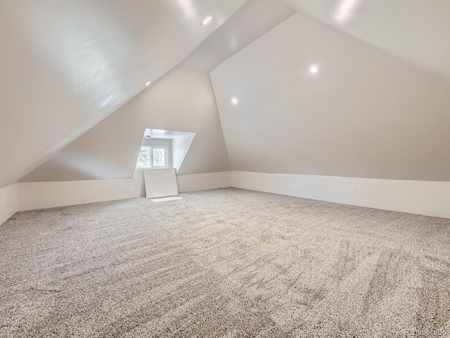 additional living space featuring vaulted ceiling and carpet