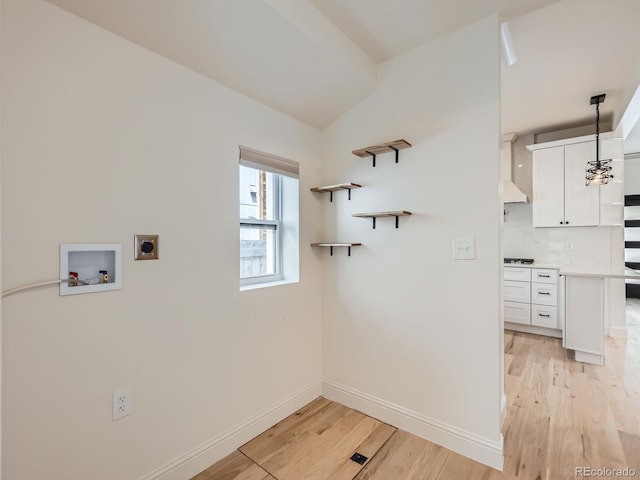 laundry room with electric dryer hookup, hookup for a washing machine, light wood finished floors, and baseboards