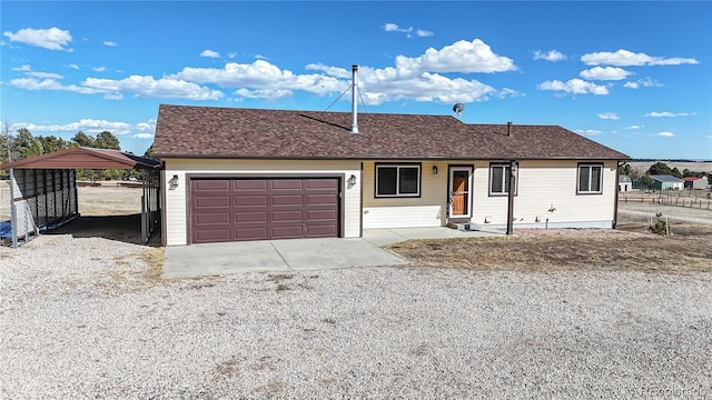 ranch-style house with an attached garage, roof with shingles, gravel driveway, and a detached carport