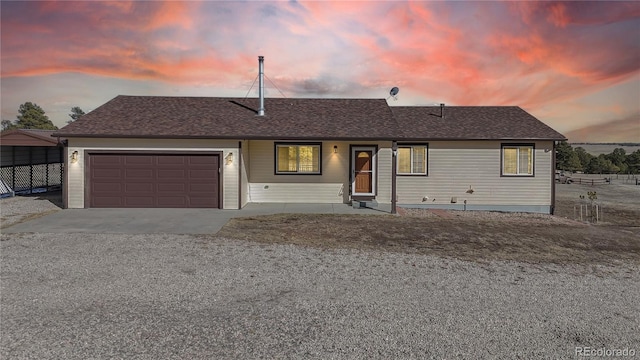 ranch-style home with a garage, concrete driveway, and a shingled roof