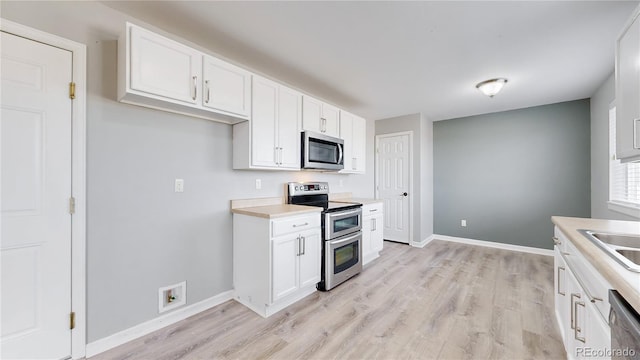 kitchen featuring stainless steel appliances, light wood-type flooring, and white cabinetry