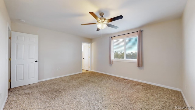 carpeted empty room featuring ceiling fan, visible vents, and baseboards