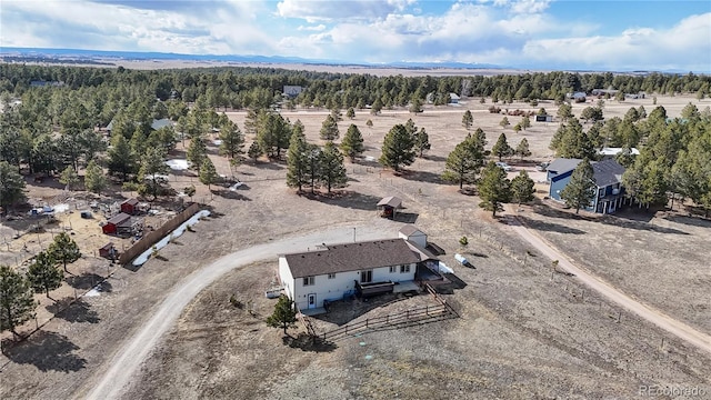 birds eye view of property featuring a forest view