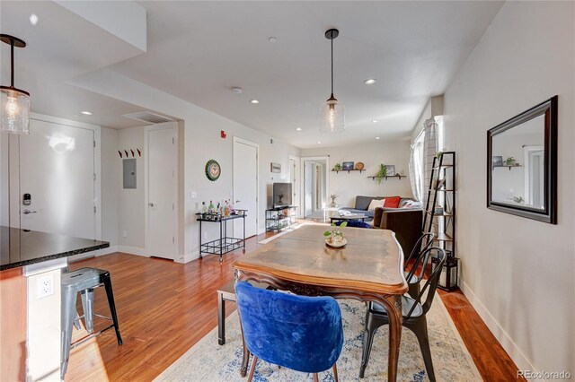 dining area with light hardwood / wood-style floors and electric panel