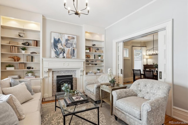 sitting room with hardwood / wood-style floors, built in features, and a notable chandelier