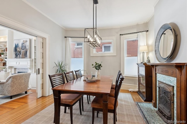 dining space with light hardwood / wood-style floors, an inviting chandelier, and crown molding