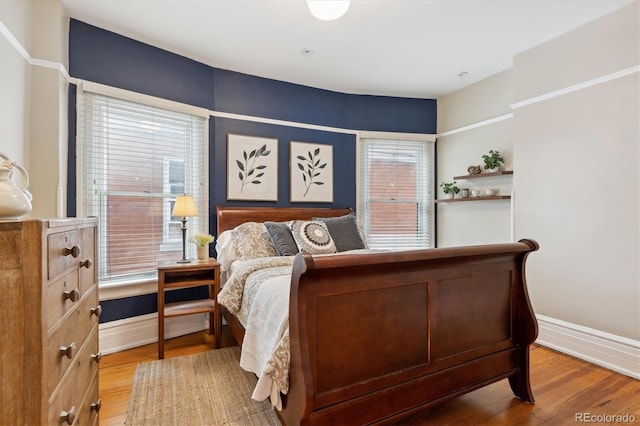 bedroom with wood-type flooring and multiple windows