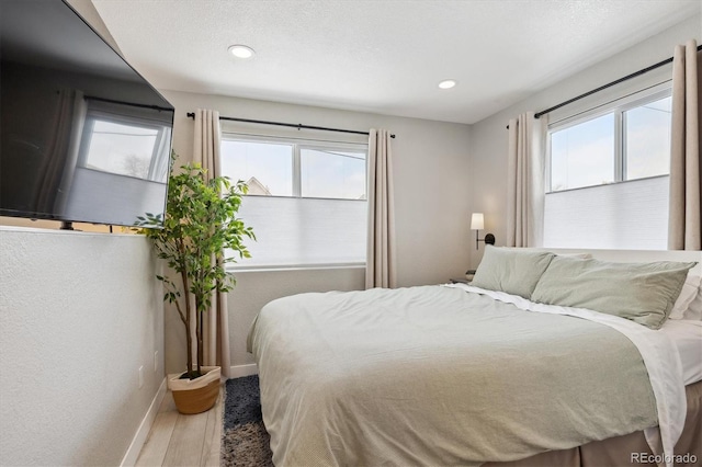 bedroom with a textured ceiling and hardwood / wood-style flooring