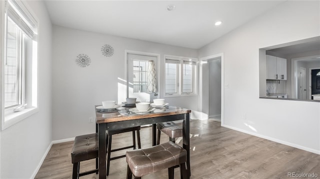 dining area featuring light wood finished floors, baseboards, and recessed lighting