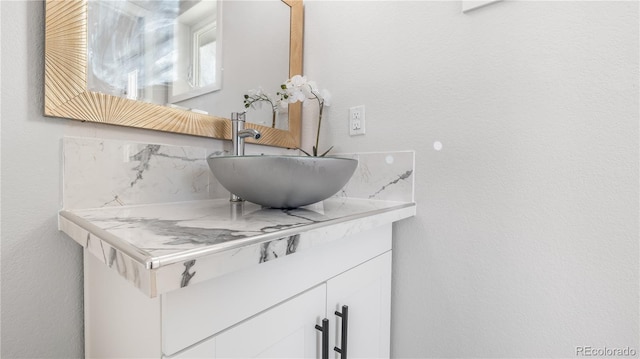 interior details featuring a textured wall and vanity