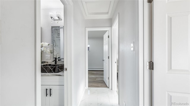 hallway featuring marble finish floor and baseboard heating