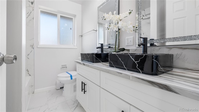 full bath featuring marble finish floor, baseboards, vanity, and toilet