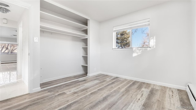 interior space featuring a baseboard heating unit, a baseboard radiator, and wood finished floors