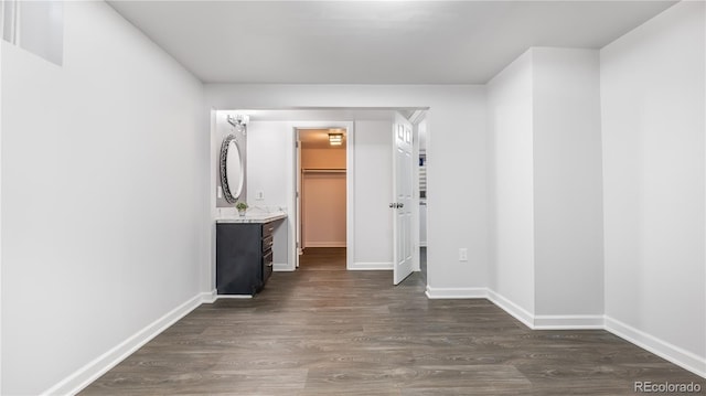 hall with dark wood-style flooring and baseboards