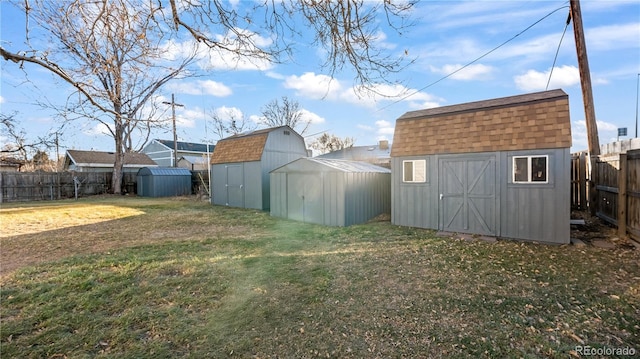 view of yard with an outbuilding, a fenced backyard, and a storage unit