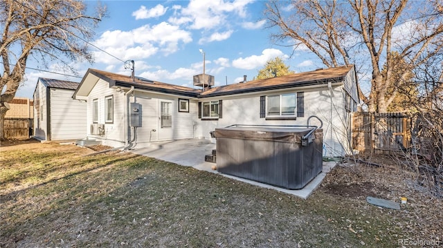 rear view of house featuring a yard, a patio area, fence, and a hot tub