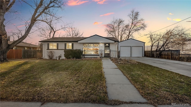 view of front of property featuring a garage, fence, an outdoor structure, and a lawn