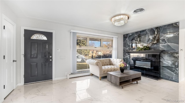 entryway with visible vents, a glass covered fireplace, a baseboard radiator, marble finish floor, and an inviting chandelier