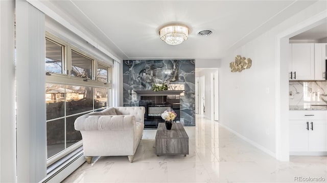 sitting room with marble finish floor, visible vents, a high end fireplace, a chandelier, and baseboards