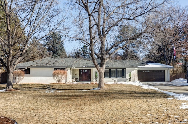 ranch-style house with a garage and a front lawn