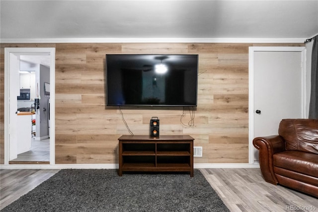 living room featuring hardwood / wood-style flooring and wooden walls