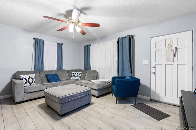 living room with ceiling fan and a textured ceiling