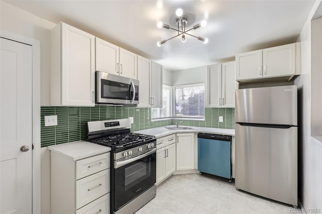 kitchen featuring white cabinets, stainless steel appliances, tasteful backsplash, and sink