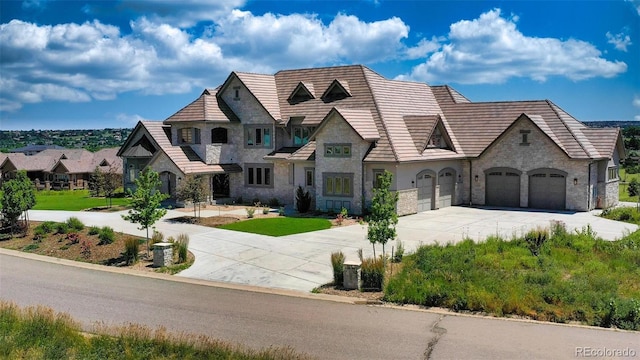 french provincial home featuring a front yard and a garage