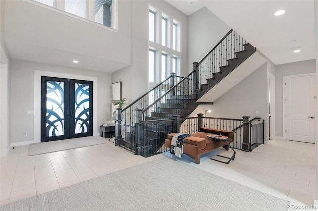 foyer entrance featuring a high ceiling, tile patterned floors, and french doors