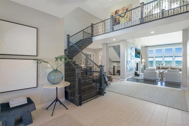 stairs with a towering ceiling and tile patterned floors